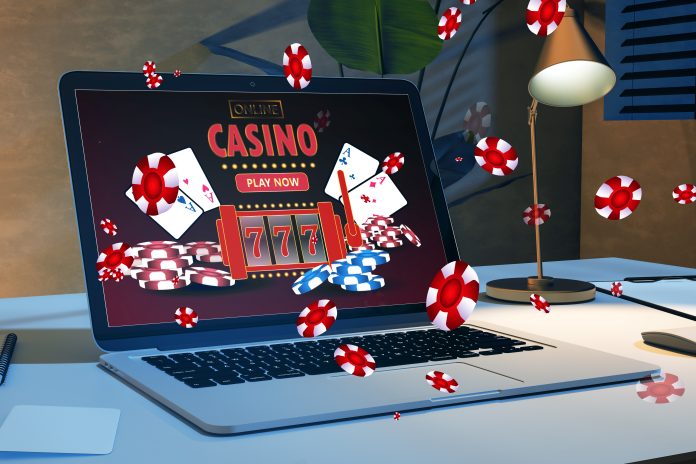 Online casino and gaming, gambling on device concept. Close up of laptop at workplace with creative slot machine and other games